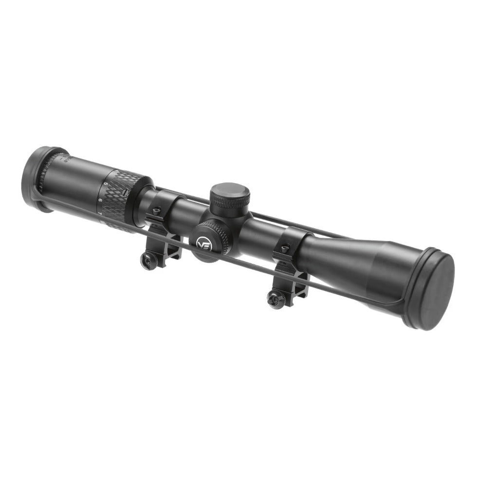 A black riflescope scope with adjustment knobs and mounting brackets, shown at an angle on a plain white background.